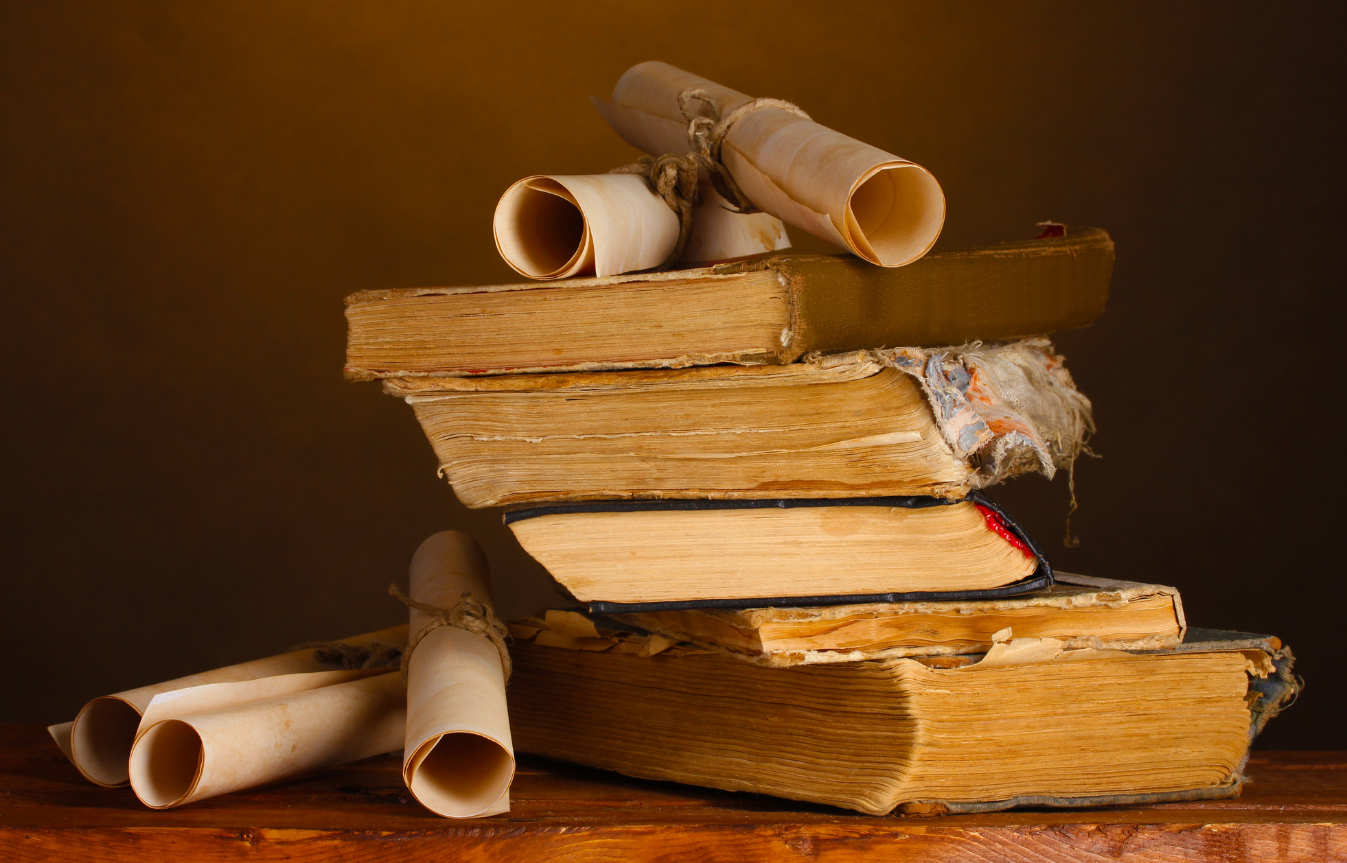 Pile of Old Books and Scroll on Brown