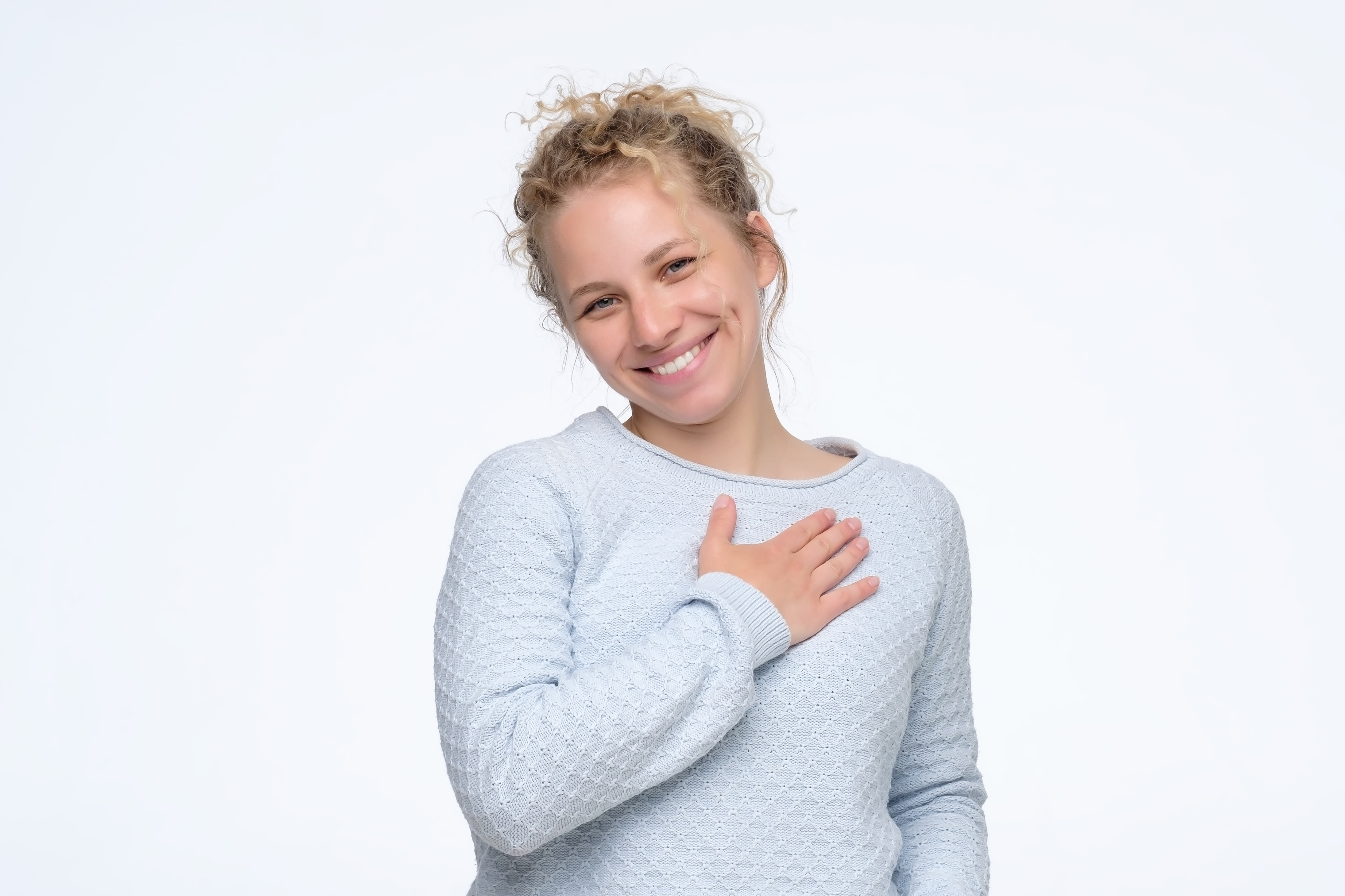 curly woman smiling broadly glad to receive compliments