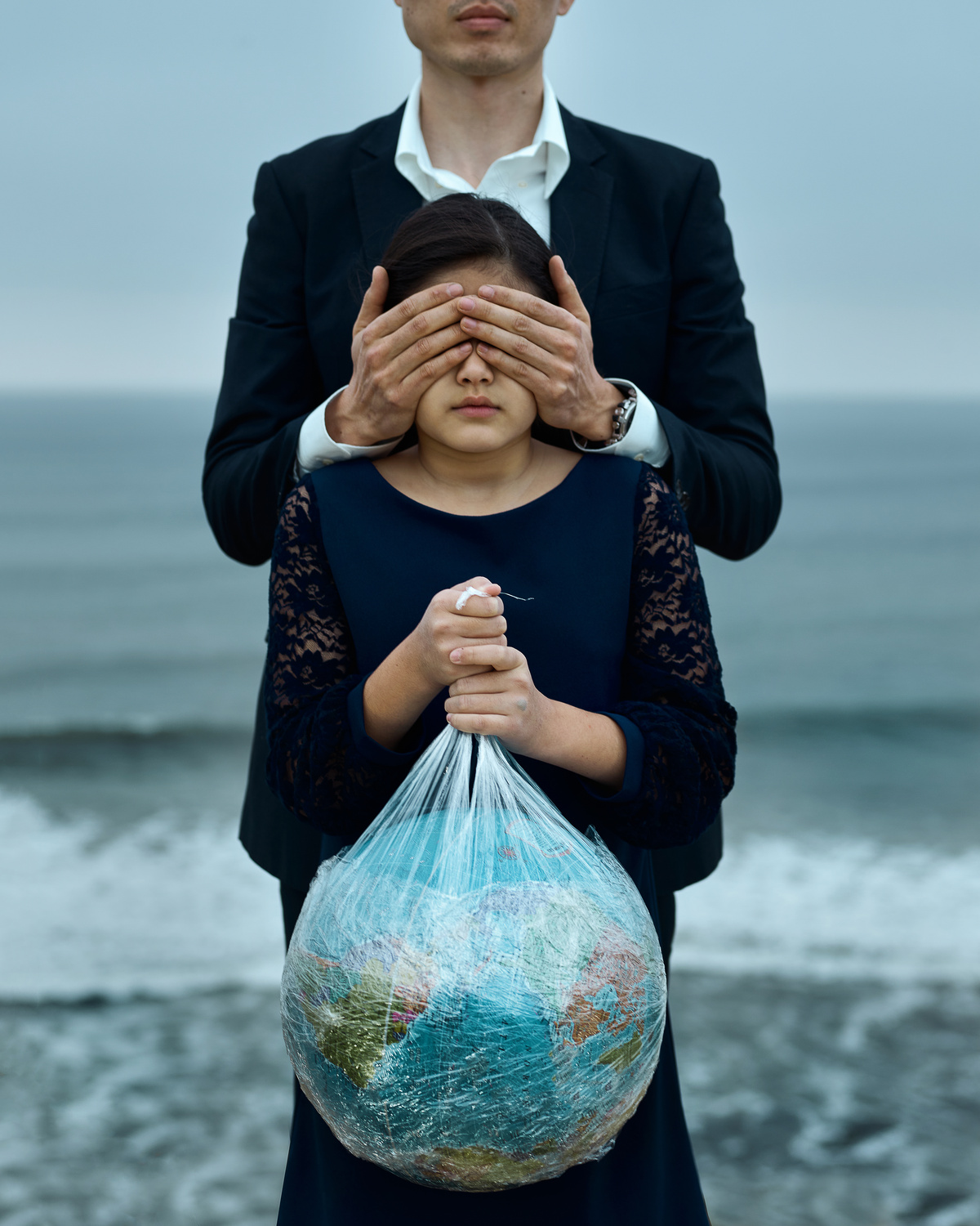 Man and girl with globe in hands and covered eyes