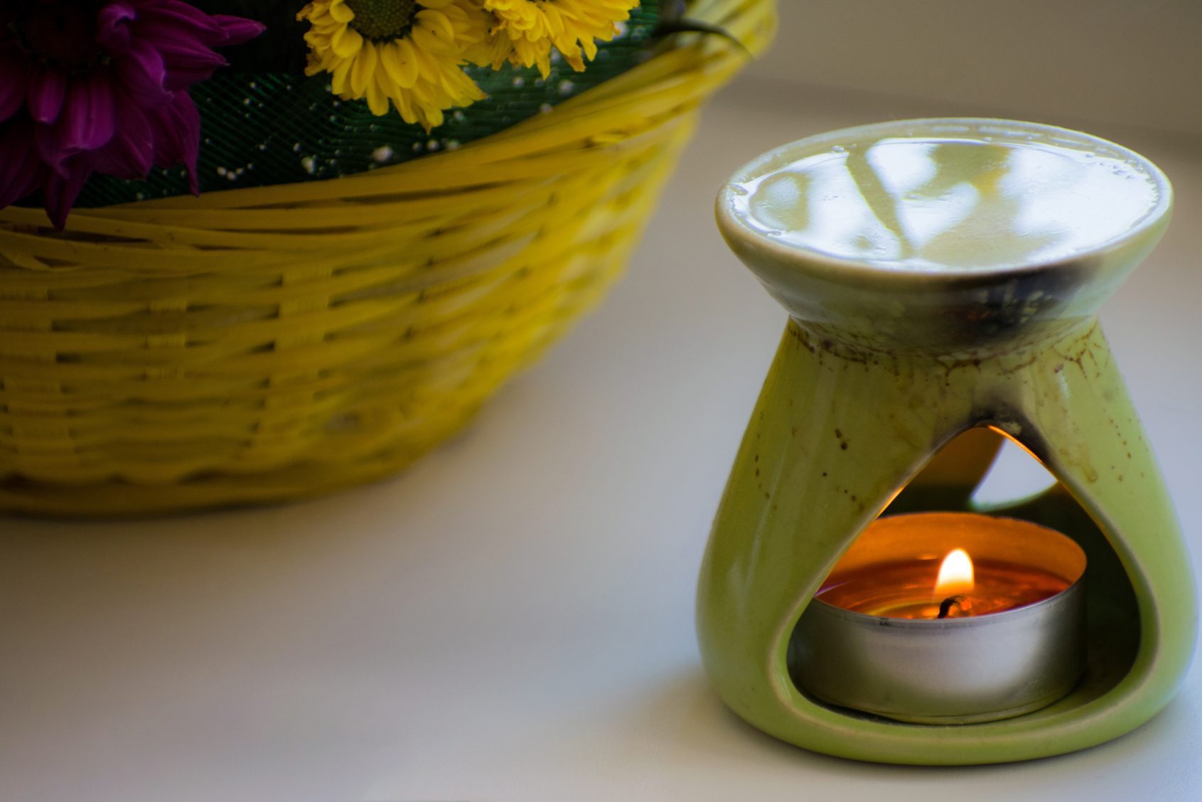 Oil burner with chrysanthemums by the side. Aromatherapy burner. Oil, aromatherapy burner, flowers and candles for spa and relaxation.