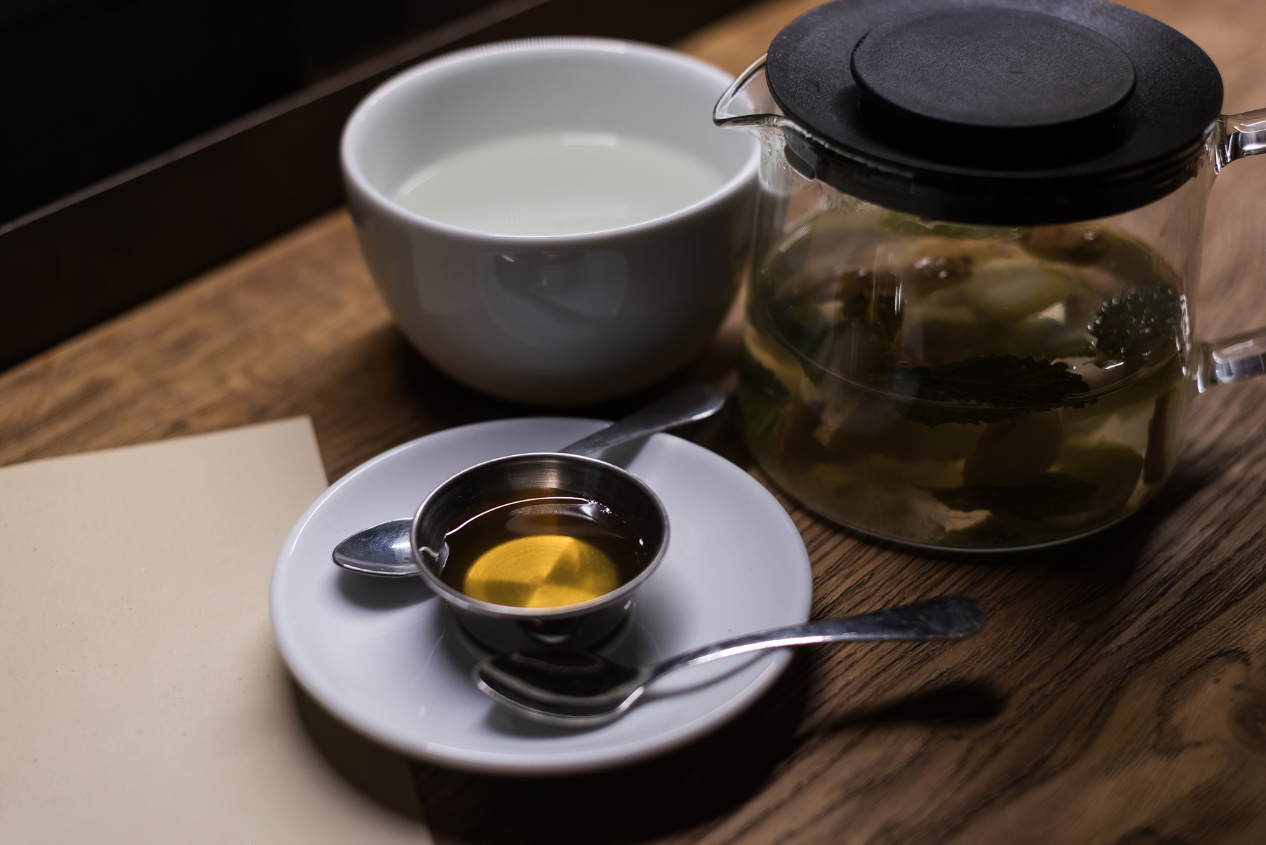 White cup for tea and tea in a scalded teapot. Tea drinking accessories and tea.