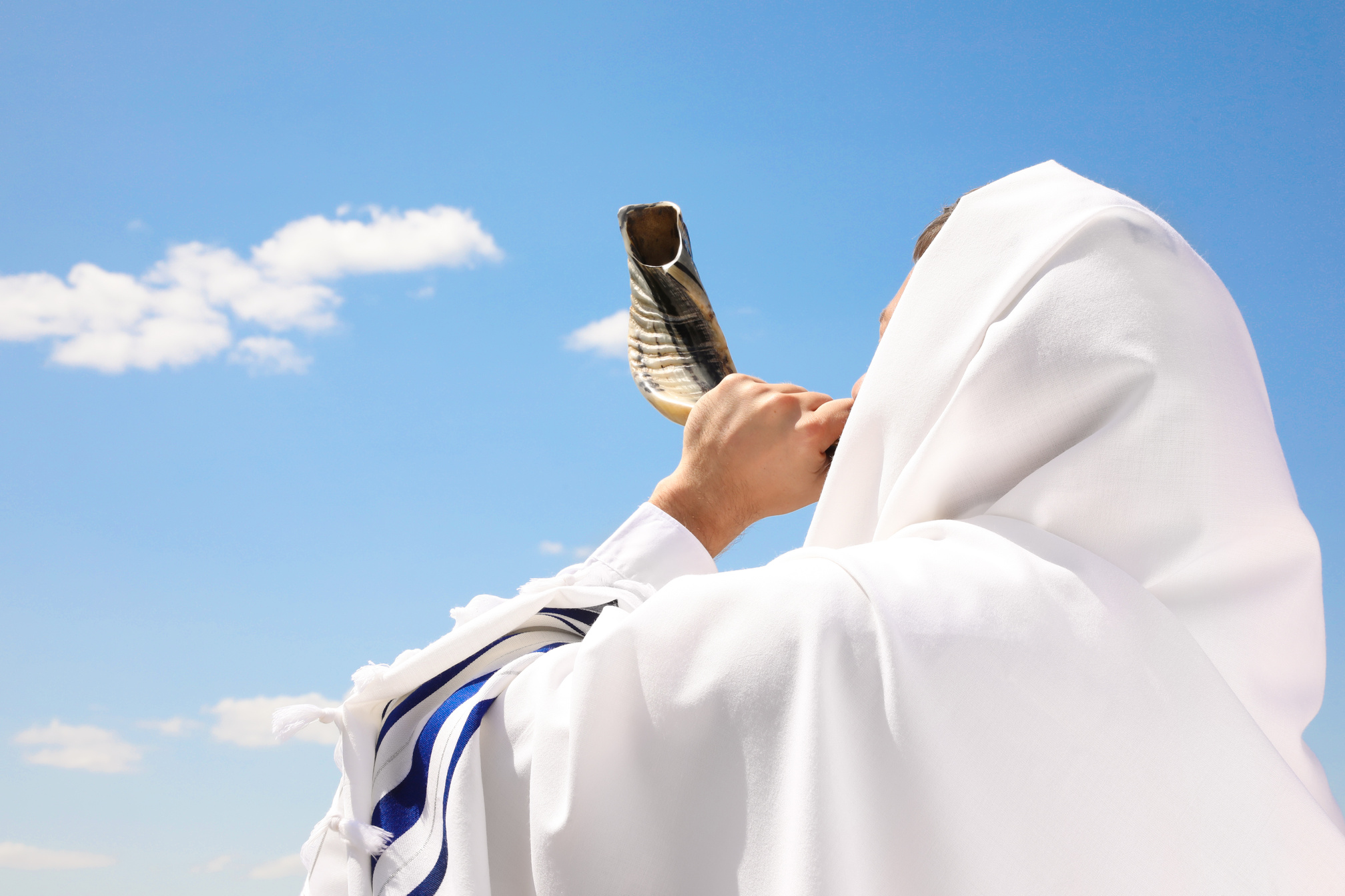 Jewish Man in Tallit Blowing Shofar Outdoors. Rosh Hashanah Cele