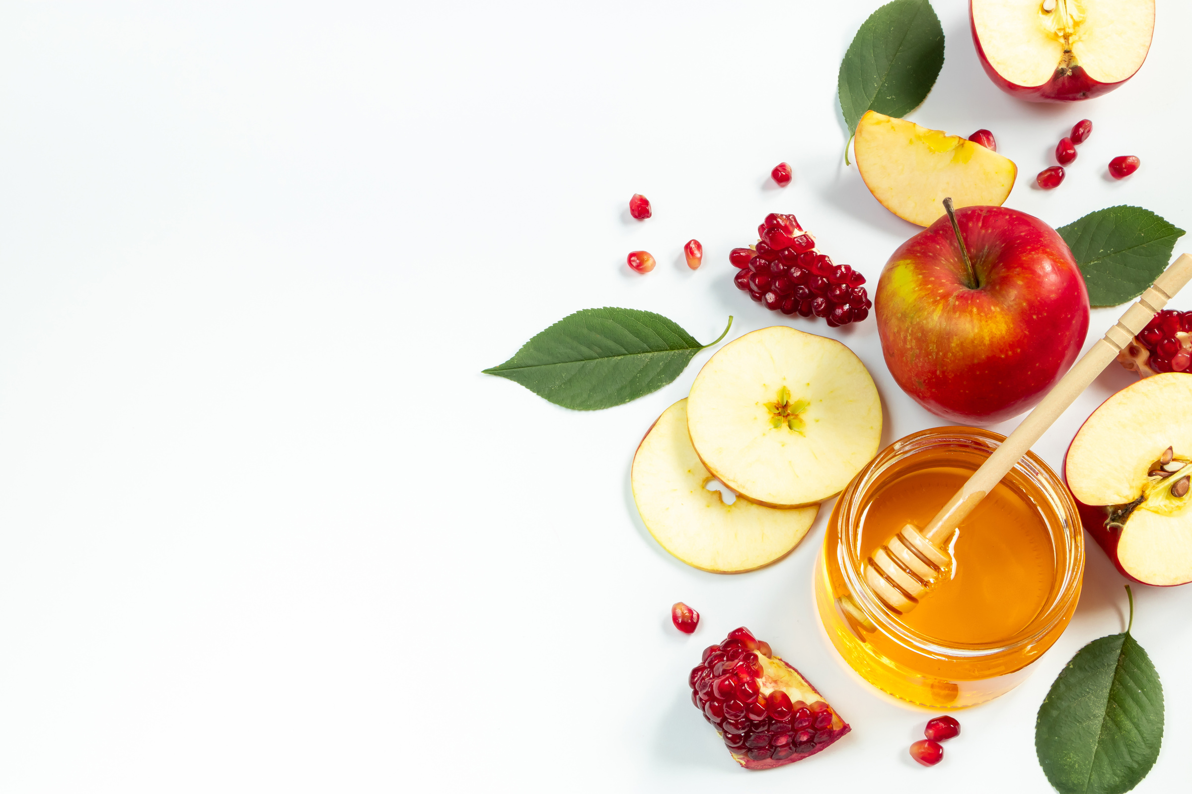 Concept of traditional Jewish holiday of Rosh Hashanah. New Year. Pomegranates, honey and apples on white background. Place for your text.