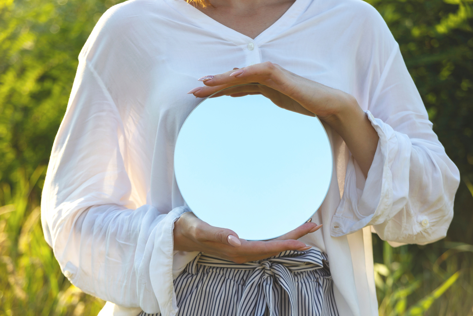 Woman Holding a Round Mirror Outdoors